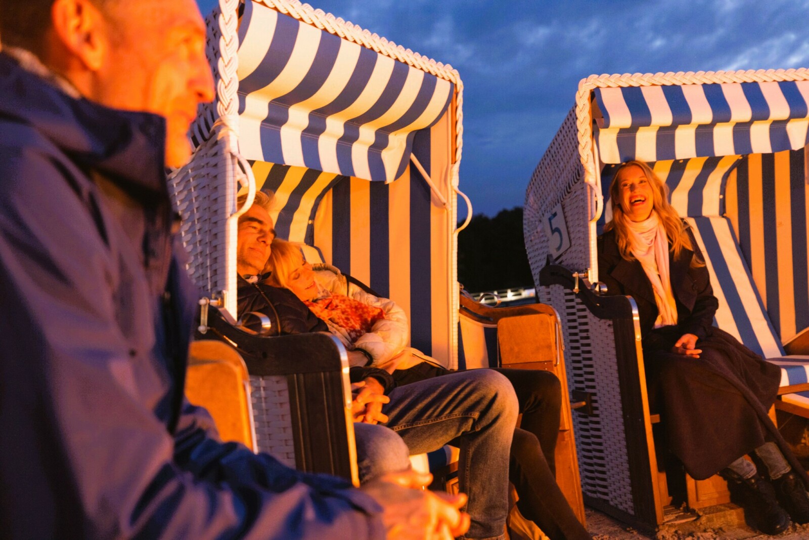 Leute sitzend abends in Strandkörben an der Müritz.