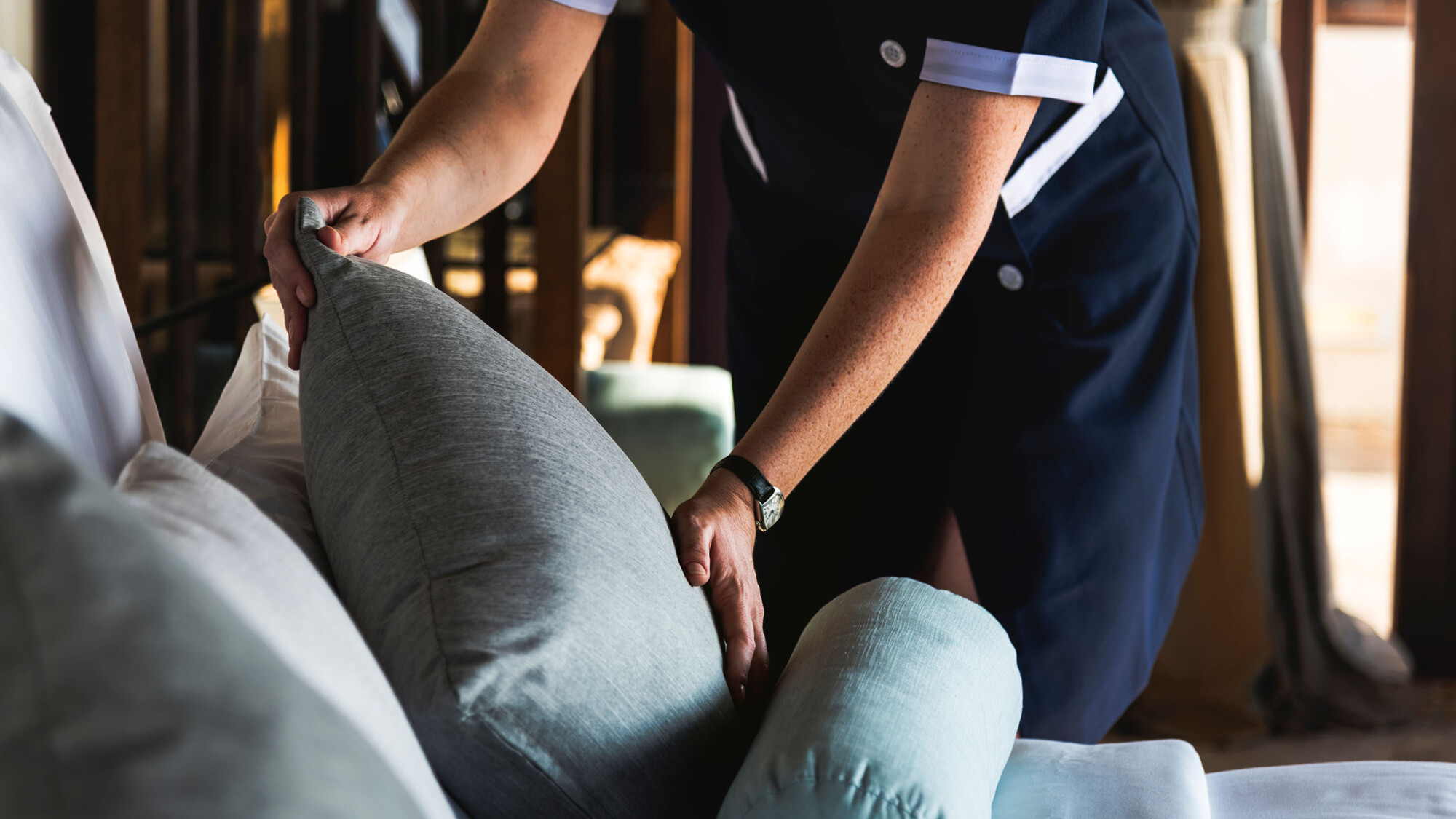 Ein Housekeeper richtet ein Kissen.