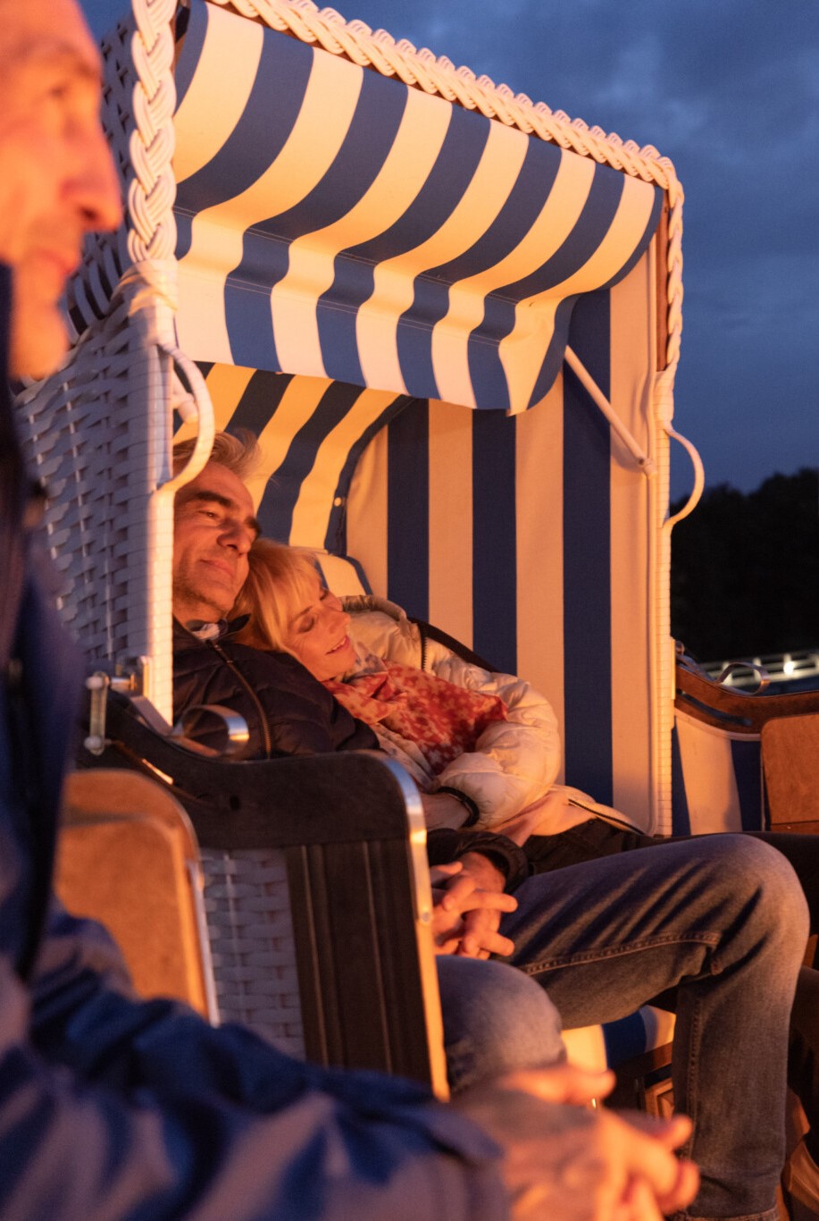 Ein Paar im Strandkorb im Feuerschein an der Müritz.