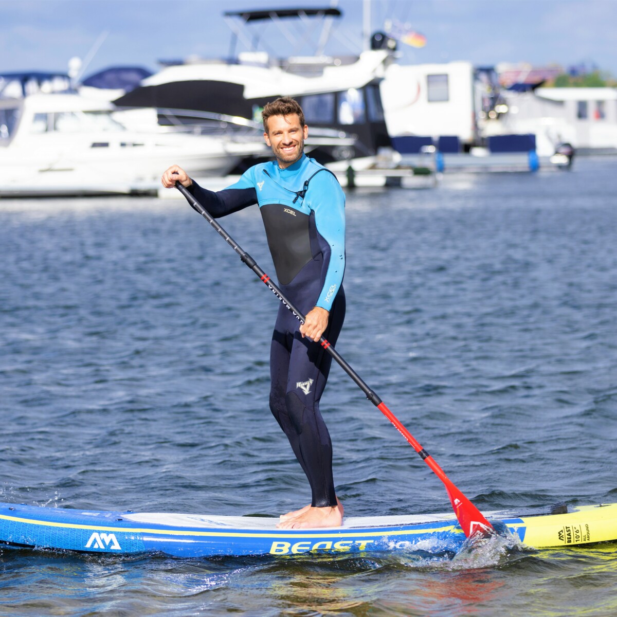 Mann beim SUP auf der Müritz am Yachthafen.
