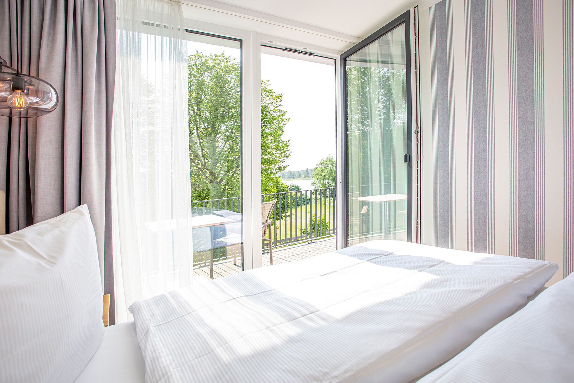 Schlafzimmer mit offener Balkontür im Aurora Appartement.