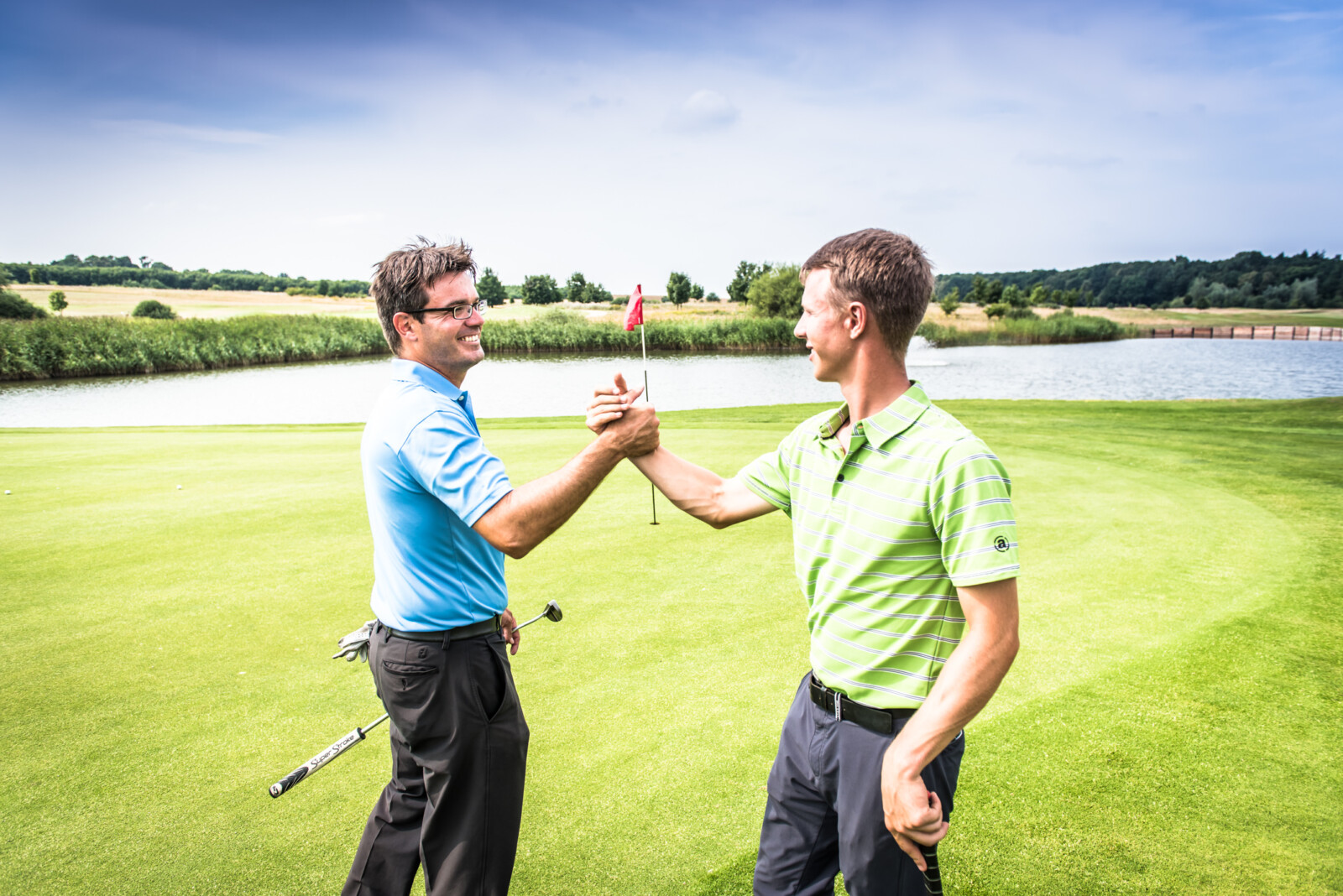 Golfer geben sich einen Handschlag auf dem Puttinggreen.