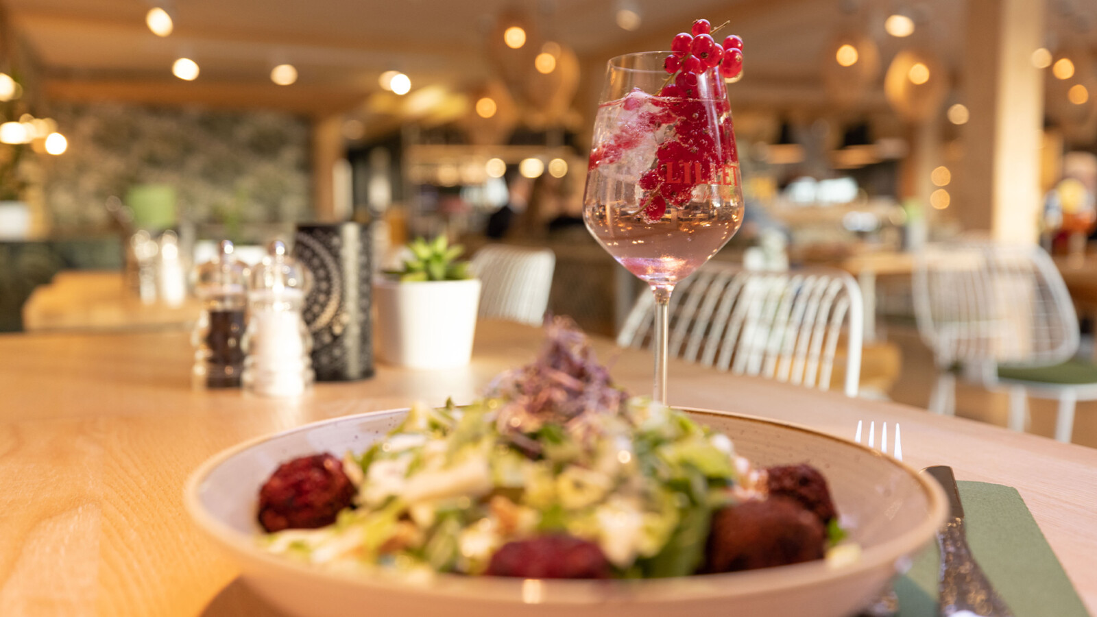 Nahaufnahme von Salat und Lillet im BellaRiva Restaurant im MareMüritz Yachthafen Resort.