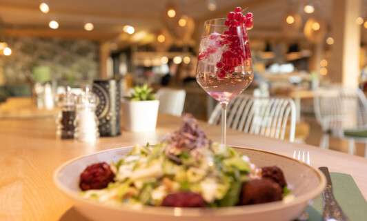 Nahaufnahme von Salat und Lillet im BellaRiva Restaurant im MareMüritz Yachthafen Resort.