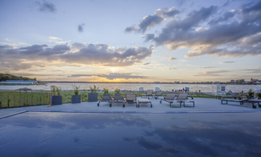 Sonnenuntergang auf der Terrasse mit Pool im MareMüritz mit Blick auf den See und Sonnenliegen.