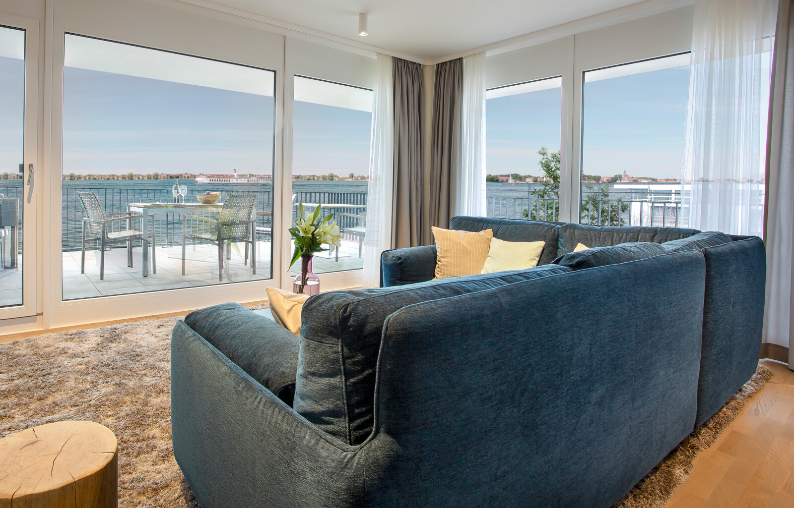 Sofa im Wohnbereich im Anker Penthouse mit Blick auf die Terrasse und die Müritz.