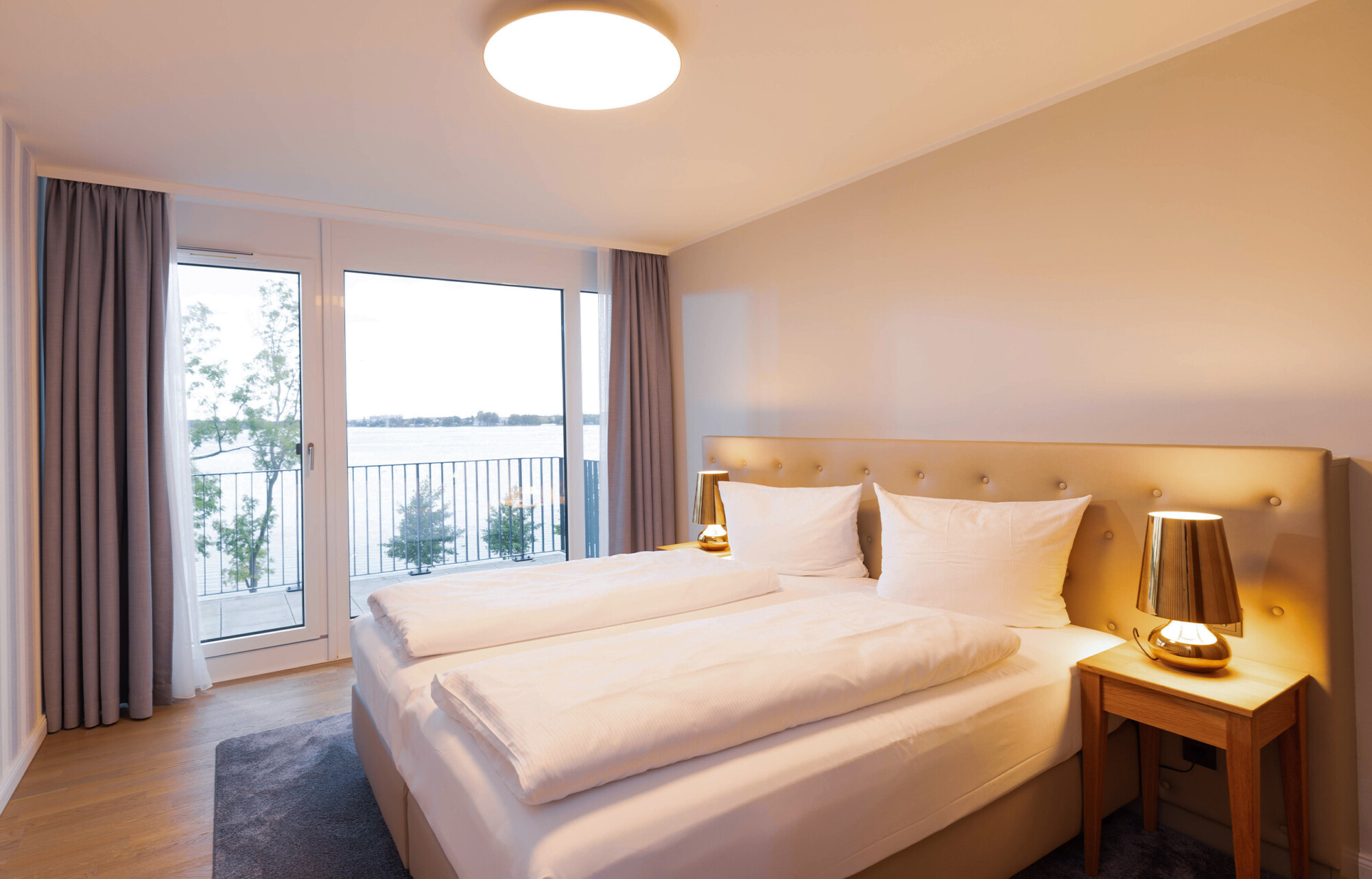 Bett im Schlafzimmer im Anker Penthouse mit Seeblick auf die Müritz.