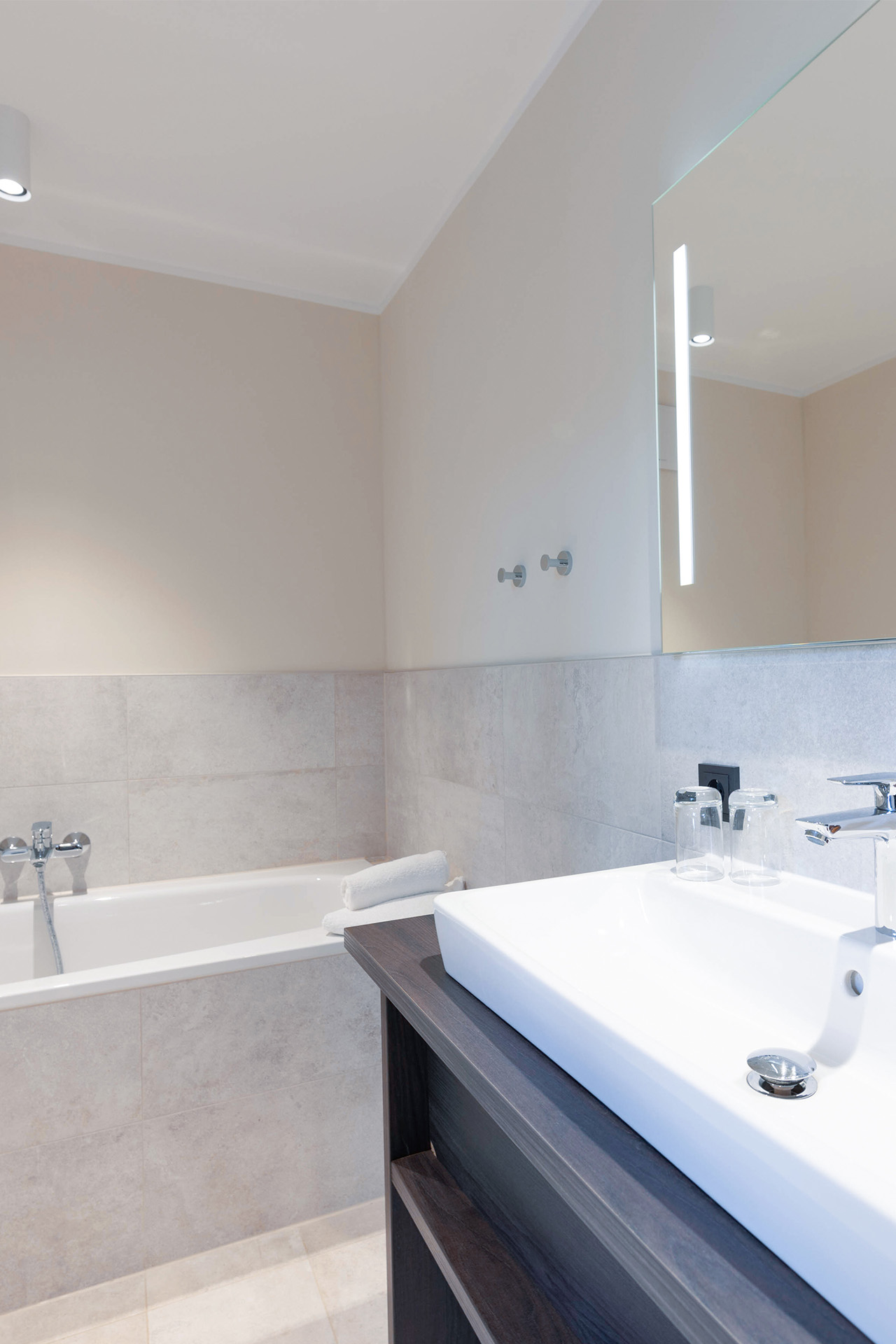 Helles Badezimmer mit Badewanne und Waschbecken in der Mare Grand Maisonette Suite.