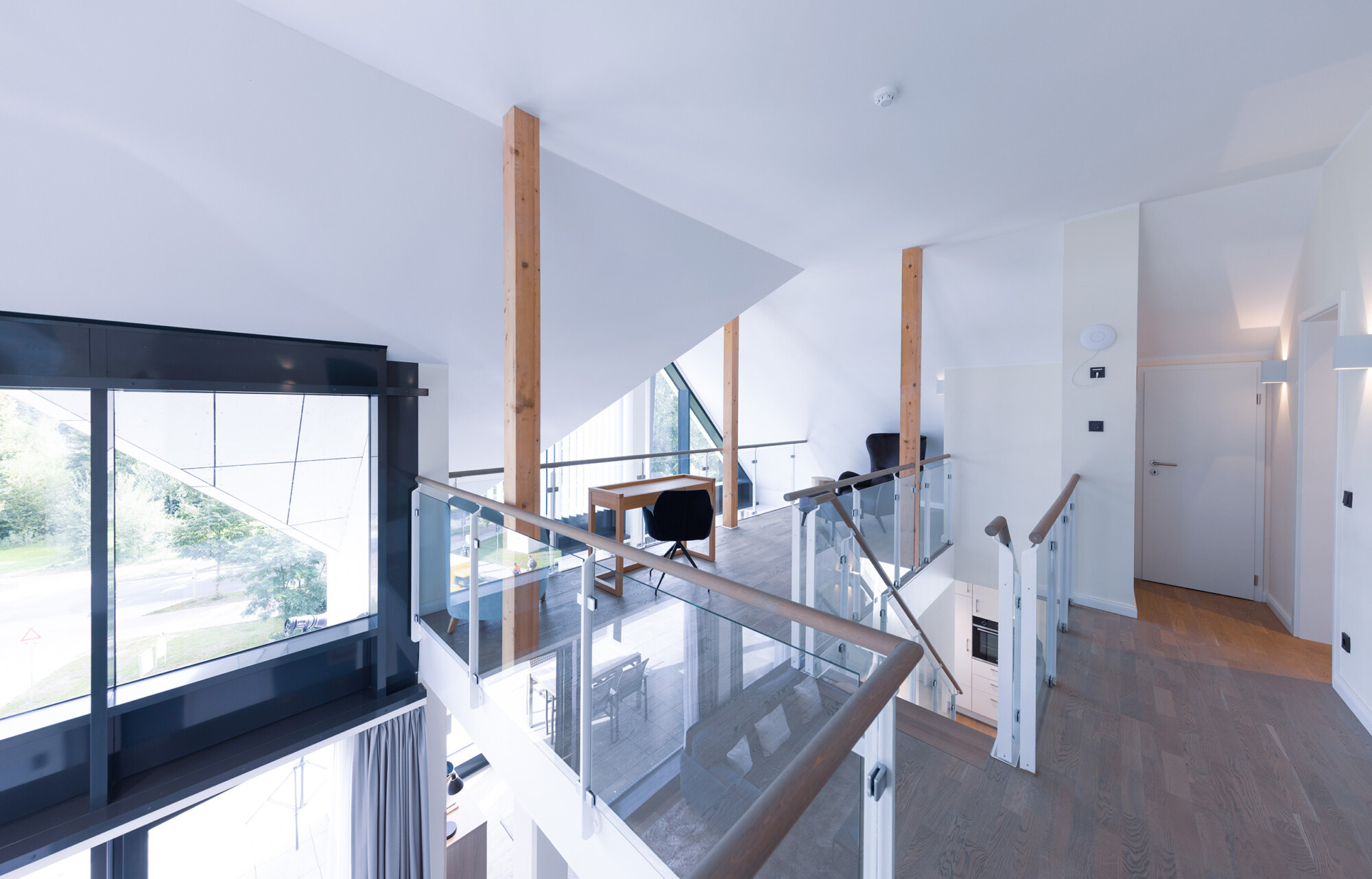 Lichtdurchfluteter Loftbereich mit großen Fenstern mit Schreibtisch und Sessel in der Mare Grand Maisonette Suite.