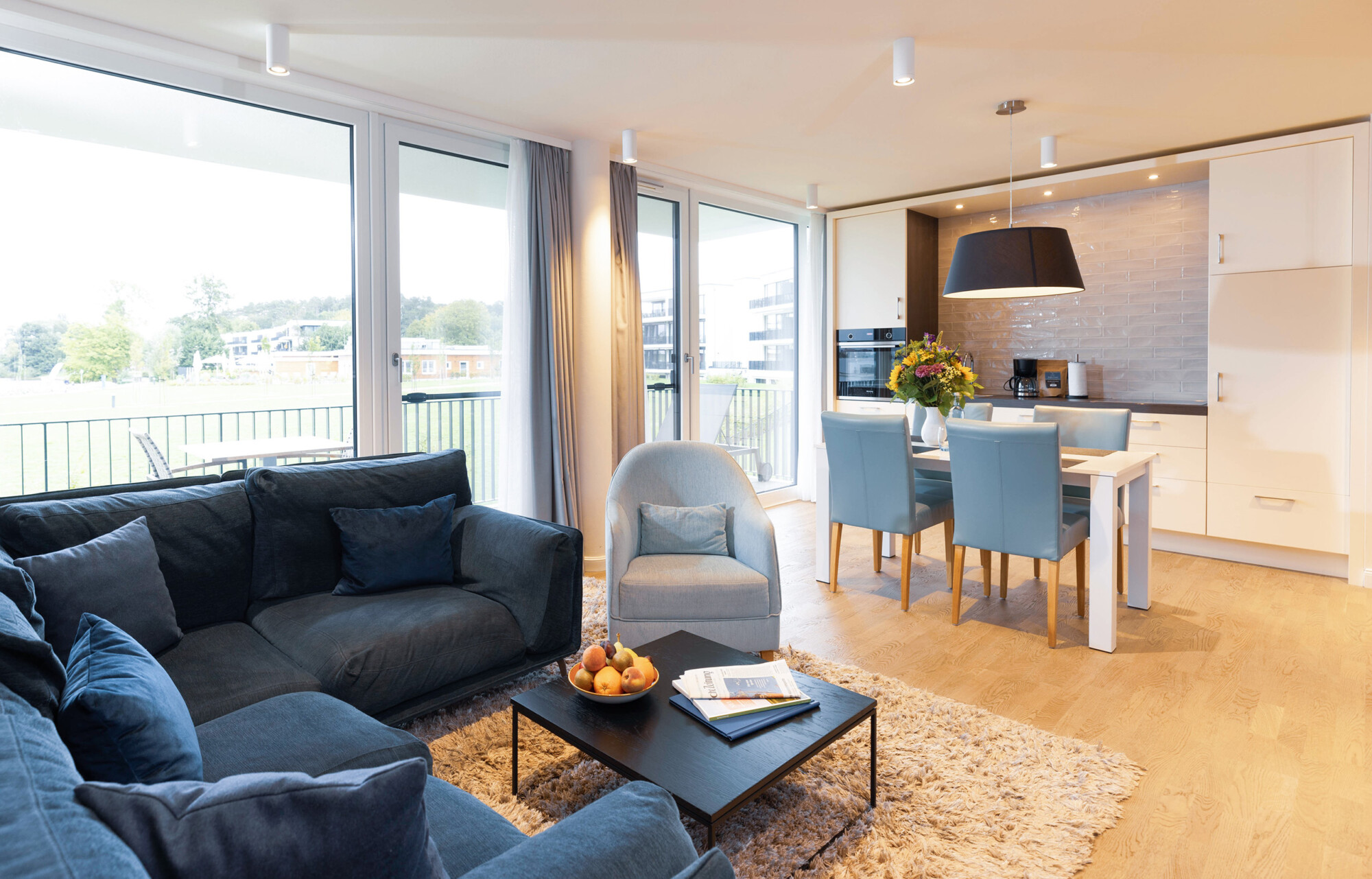 Gemütliches Sofa im Wohnbereich mit Esstisch und Küche in der Fortuna Suite.