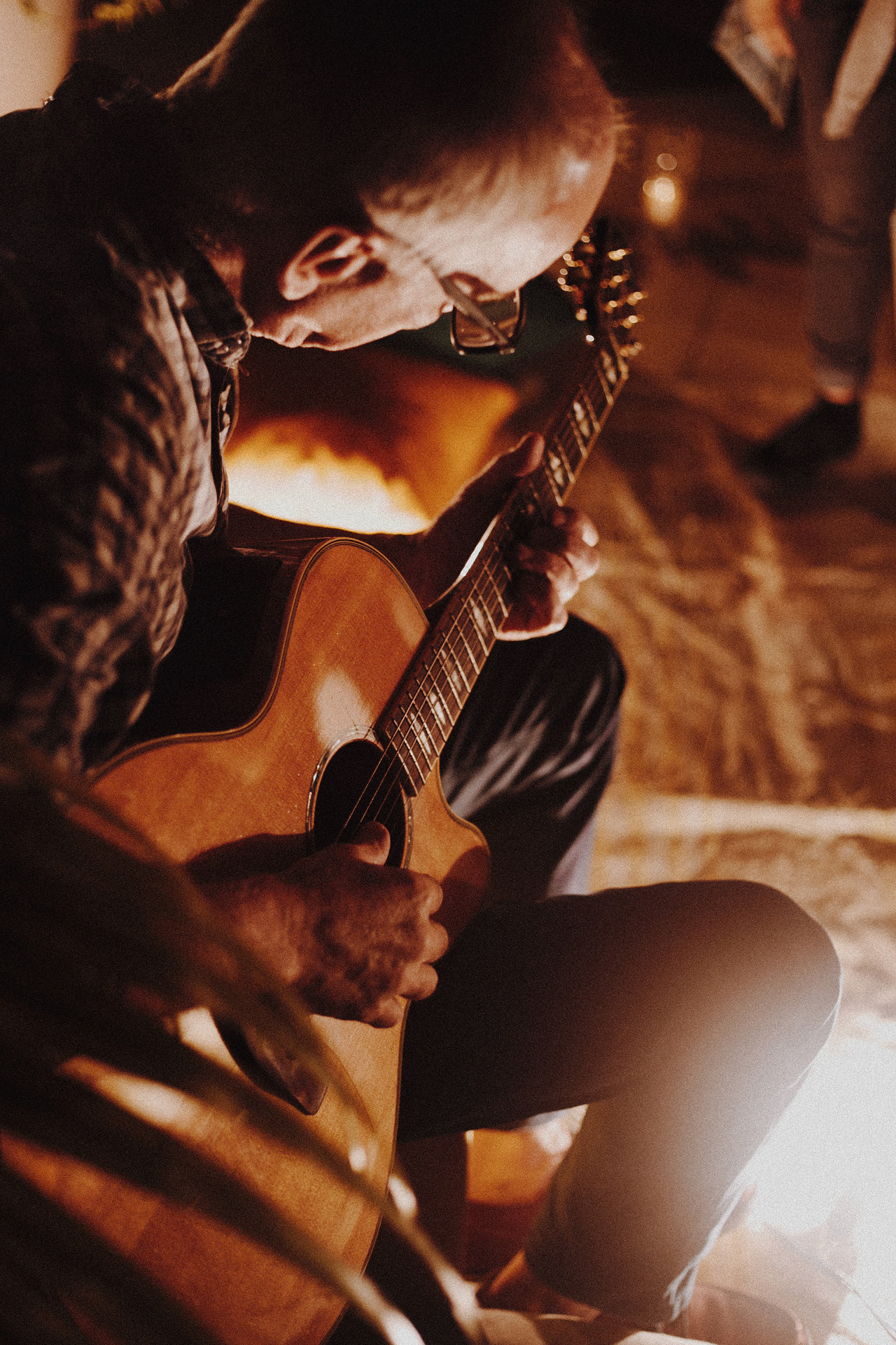 Musiker sitzt und spielt Gitarre.