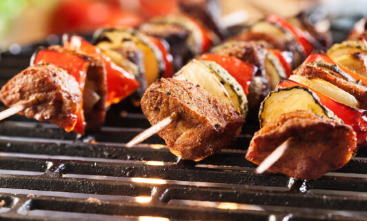 Grillspieße auf dem Grill mit Fleisch und Paprika.