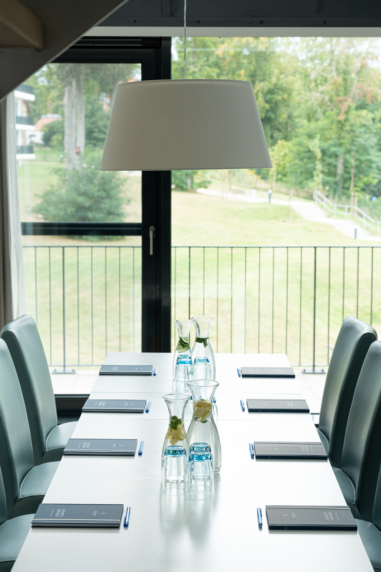 Ein Tisch für eine Tagung mit Blick auf eine grüne Wiese.
