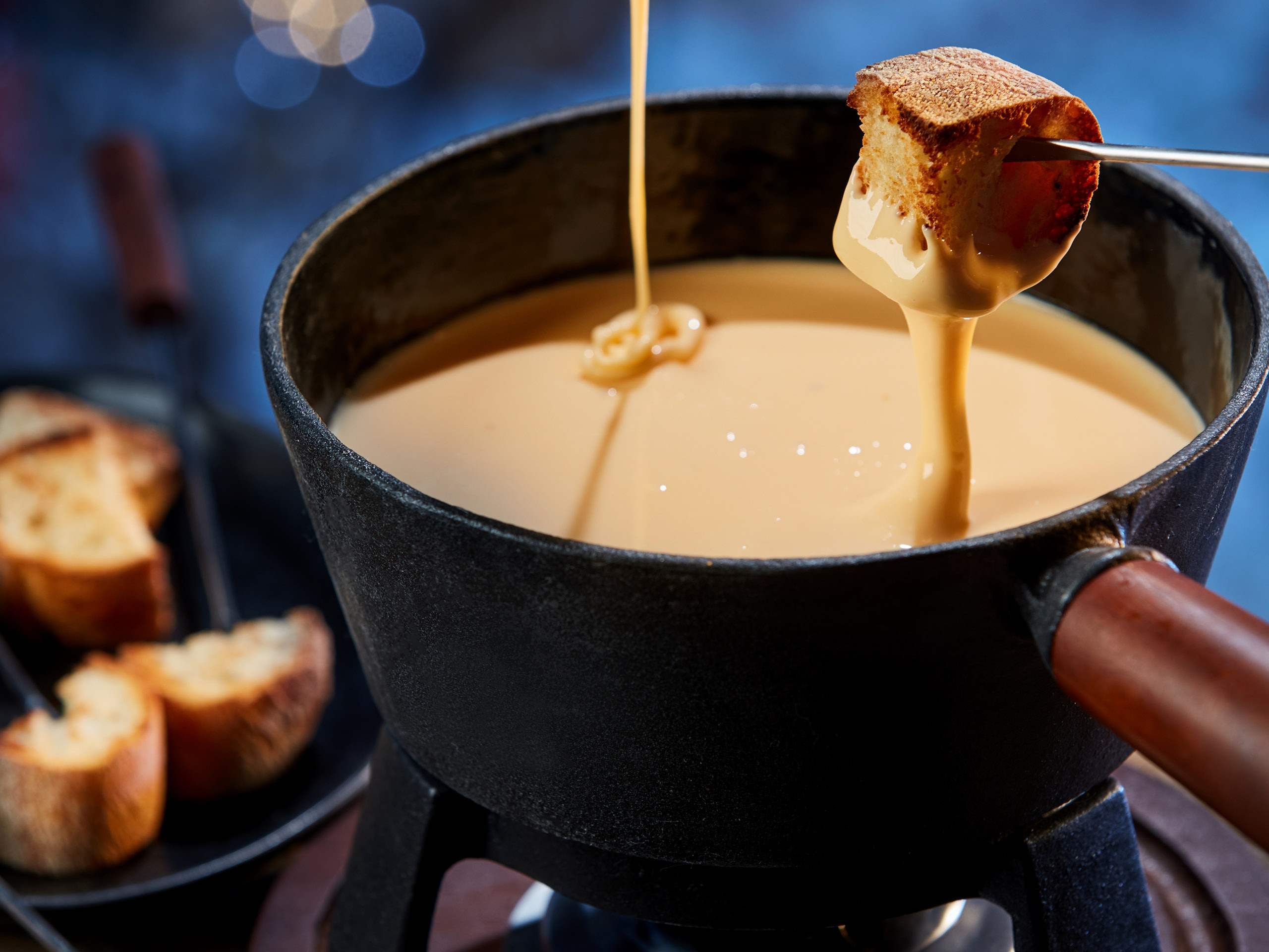Brot wird in Käse Fondue getunkt