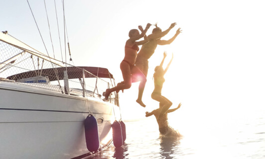 Gruppe springt vom Boot ins Wasser